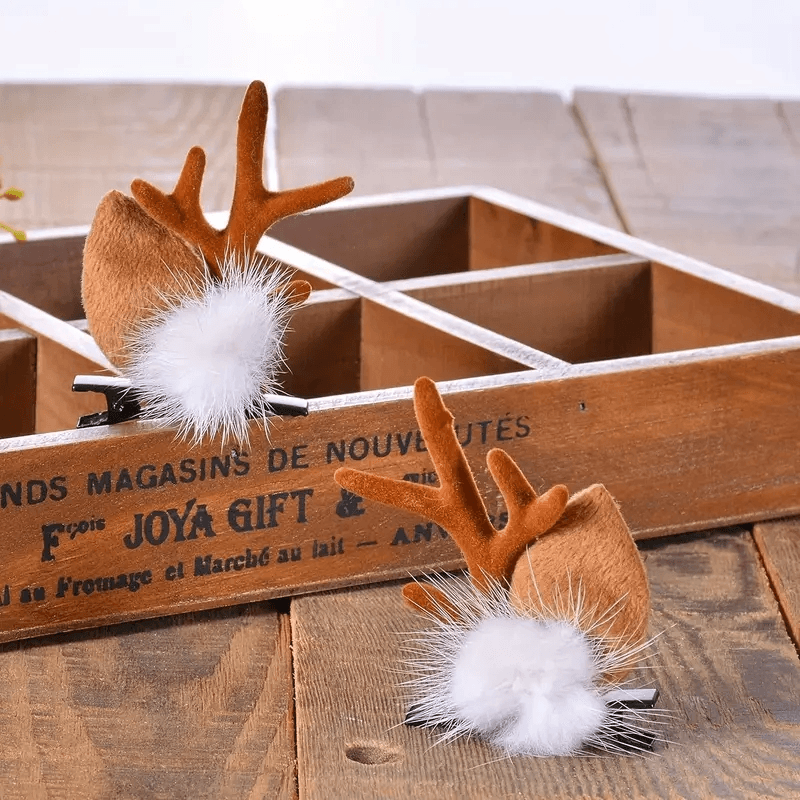 `Ahşap zemin üzerinde duran kahverengi kulaklı ve ponponlu ren geyiği saç tokası`